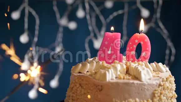 生日蛋糕与40号燃烧粉红色蜡烛和闪闪发光的蓝色背景慢速运动和特写镜头视频的预览图