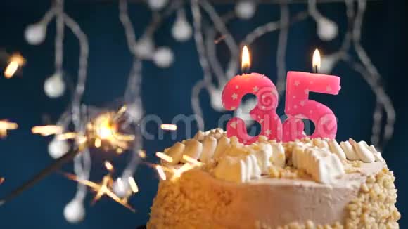 生日蛋糕与35号燃烧粉红色蜡烛和闪闪发光的蓝色背景慢速运动和特写镜头视频的预览图