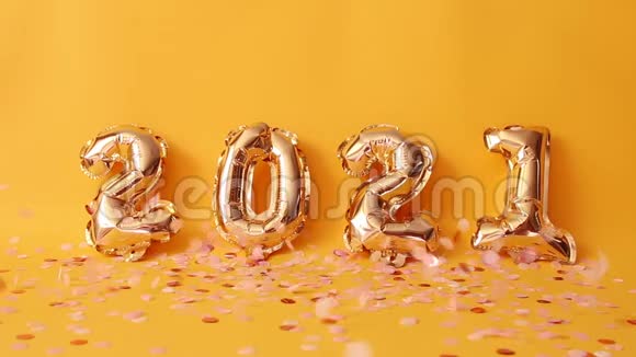 金色2021号氦气球黄色背景上有粉红色闪光的五彩纸屑视频的预览图