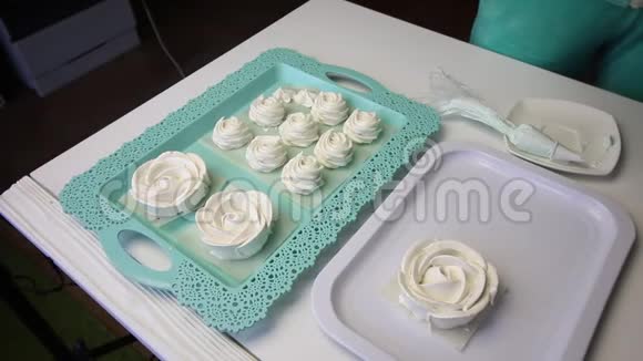 在托盘上的桌子表面棉花糖以经典的形状和玫瑰的形式传播有棉花糖的看台视频的预览图