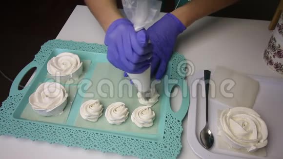 托盘上摆着一个玫瑰形的棉花糖一个女人在糕点袋的帮助下形成了一个经典形状的棉花糖视频的预览图