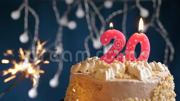 生日蛋糕20个数字燃烧粉红色蜡烛和闪闪发光的蓝色背景慢速运动和特写镜头视频的预览图
