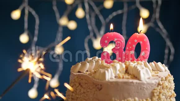 生日蛋糕与30号燃烧粉红色蜡烛和闪闪发光的蓝色背景慢速运动和特写镜头视频的预览图