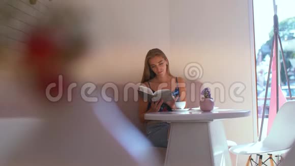 咖啡馆里翻阅一本书的女孩视频的预览图
