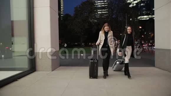 女性牵着手微笑着喜欢一起散步穿着时尚的衣服视频的预览图