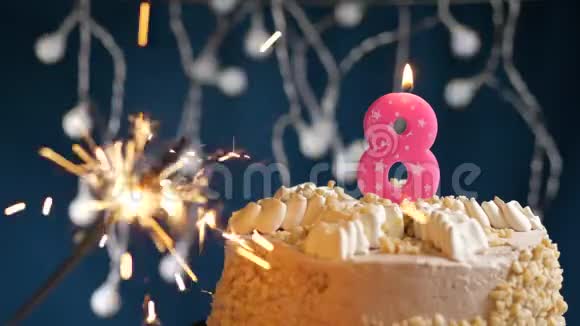 生日蛋糕与8号燃烧粉红色蜡烛和闪闪发光的蓝色背景慢速运动和特写镜头视频的预览图