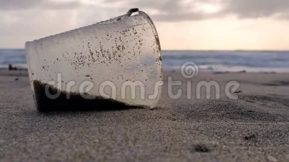 沙质海岸上的塑料玻璃垃圾日落风运动污染自然4k视频的预览图
