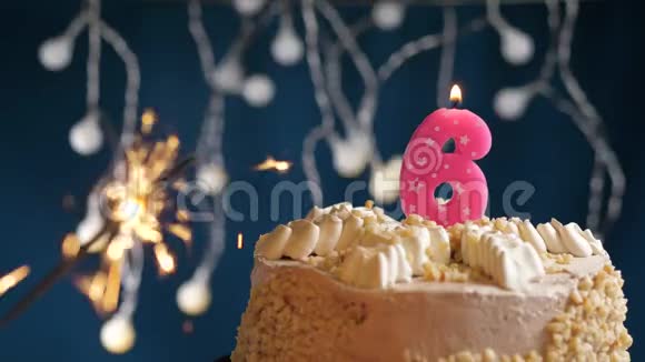 生日蛋糕与6号燃烧粉红色蜡烛和闪闪发光的蓝色背景慢速运动和特写镜头视频的预览图