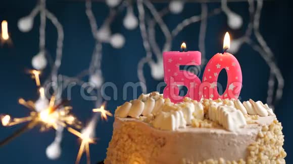 生日蛋糕50个数字燃烧粉红色蜡烛和闪闪发光的蓝色背景慢速运动和特写镜头视频的预览图