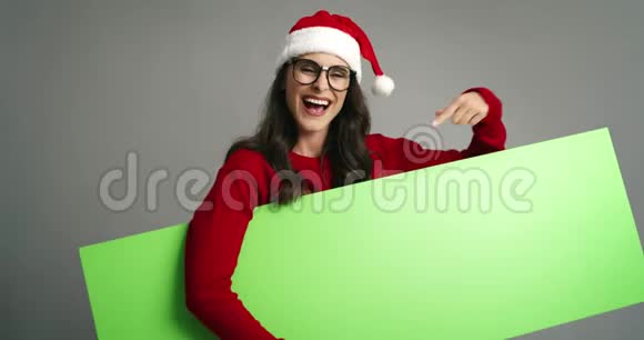 女士指着带有复制空间的圣诞绿幕横幅视频的预览图