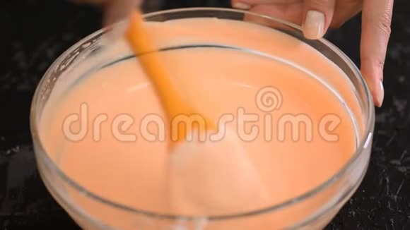 雌性的手用铲子搅拌橙色的摩丝视频的预览图