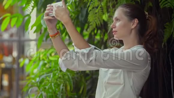 千禧白种人女性在暑假期间使用智能手机自拍视频的预览图