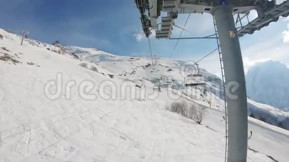 冬天的全景滑雪电梯和雪覆盖的山在一个阳光明媚的日子视频的预览图