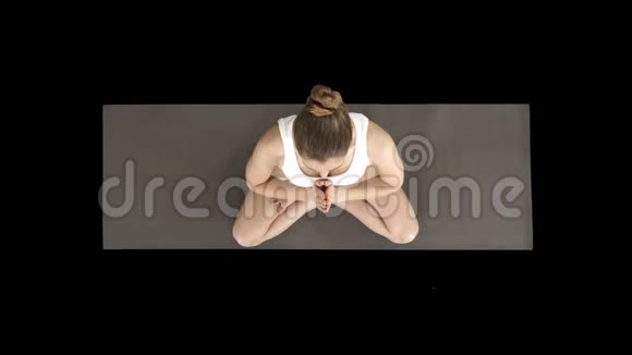 年轻的瑜伽女性练习瑜伽用莲花姿势做名字手势穿白色t恤阿尔法频道视频的预览图