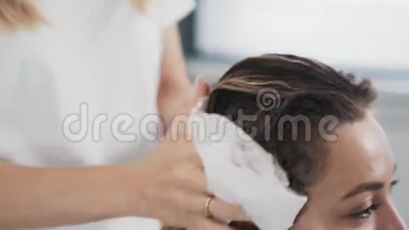 美发师在美容院洗完后用毛巾擦干女人的头发视频的预览图
