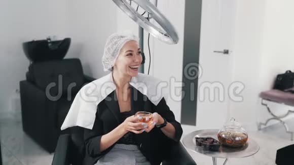 在美容院做头发护理喝茶放松的年轻女性视频的预览图