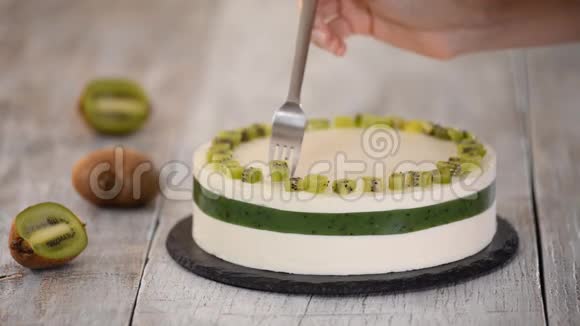 厨师用新鲜的猕猴桃装饰蛋糕自制摩丝蛋糕加奇异果视频的预览图