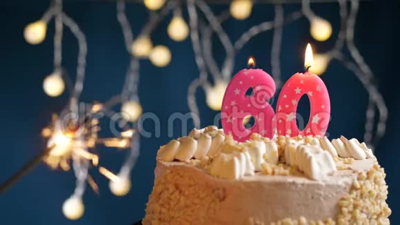 生日蛋糕60个数字燃烧粉红色蜡烛和闪闪发光的蓝色背景慢速运动和特写镜头视频的预览图