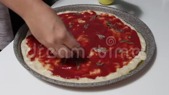 一个女人的手在比萨饼上加瓶盖来煮视频的预览图