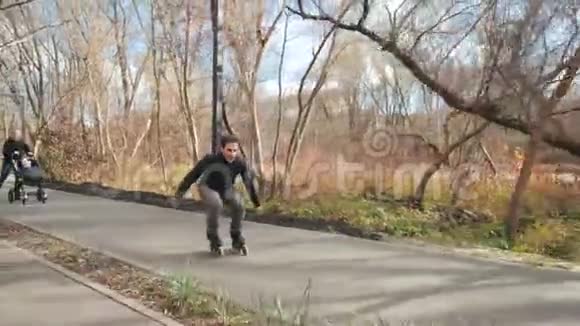 体育运动年轻的父母带着一个孩子走在秋天阳光明媚的公园里骑着溜冰鞋爸爸骑在前面跳起来视频的预览图