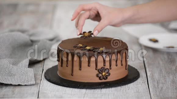 甜点面包师用巧克力花装饰美丽的奶油蛋糕视频的预览图