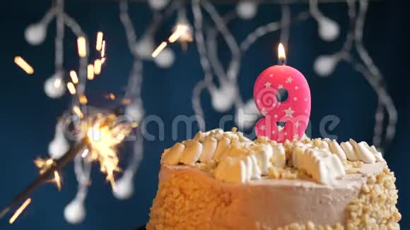生日蛋糕与9号燃烧粉红色蜡烛和闪闪发光的蓝色背景慢速运动和特写镜头视频的预览图