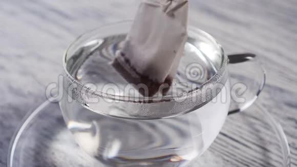一袋红茶滴在一个透明的杯子里视频的预览图
