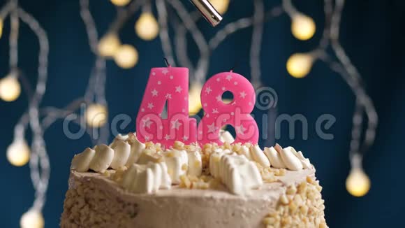 生日蛋糕48个数字燃烧由较轻的粉红色蜡烛在蓝色的背景蜡烛被点燃了慢动作视频的预览图