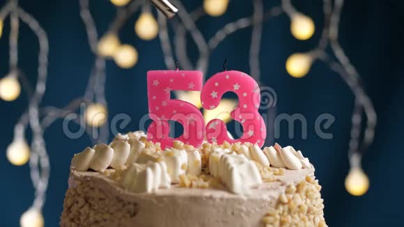 生日蛋糕有53个数字由较轻的粉红色蜡烛在蓝色的背景上燃烧蜡烛被点燃了慢动作视频的预览图