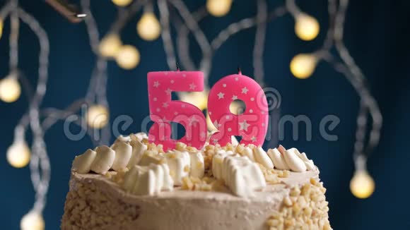 生日蛋糕59个数字燃烧由较轻的粉红色蜡烛在蓝色的背面蜡烛被点燃了慢动作视频的预览图