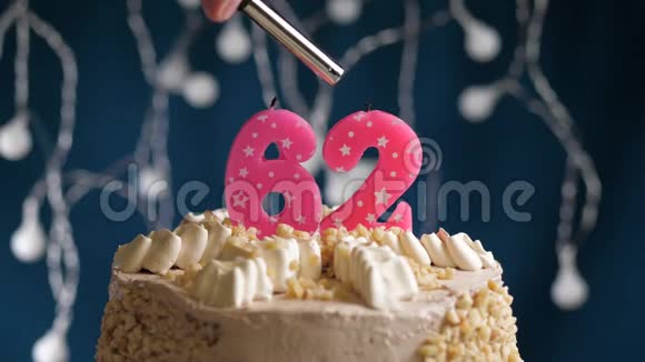 生日蛋糕有62个数字由较轻的粉红色蜡烛燃烧在蓝色的背景上蜡烛被点燃了慢动作视频的预览图