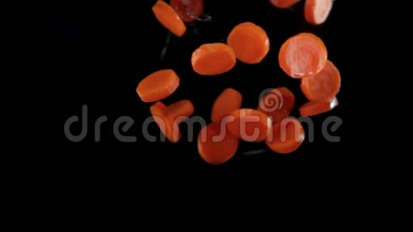新鲜切碎的有机胡萝卜在黑色背景上飞起来视频的预览图