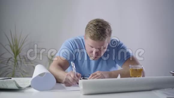一幅自信的白种人建筑师坐在桌子旁写在蓝图上的肖像专业设计师吃饭视频的预览图