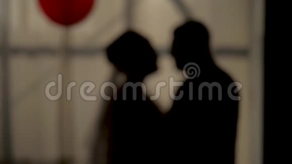 新娘和新郎亲吻浪漫的背景下日落窗口剪影拍摄中镜头和慢动作视频的预览图