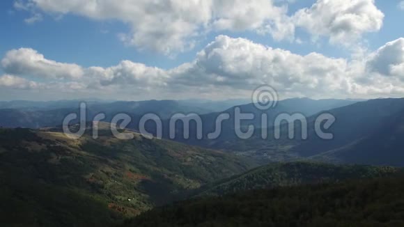 空中飞行在高山上的森林上空穿过云层视频的预览图