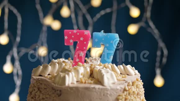 生日蛋糕77个数字燃烧由较轻的粉红色蜡烛在蓝色的背面蜡烛被点燃了慢动作视频的预览图