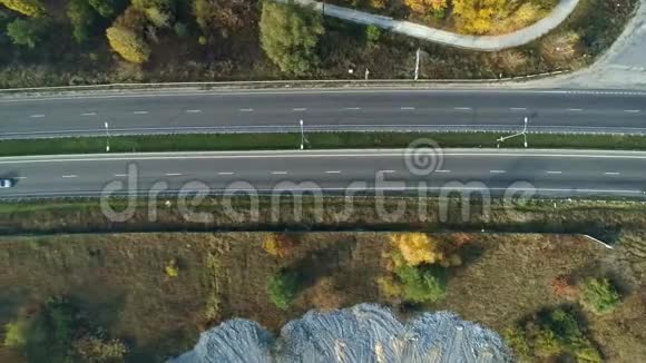 空中无人机镜头飞越高速公路附近森林顶景拍摄视频的预览图