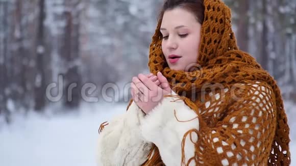 一位在户外散步的年轻女子在冬天的公园里呼吸以保暖的肖像慢慢视频的预览图
