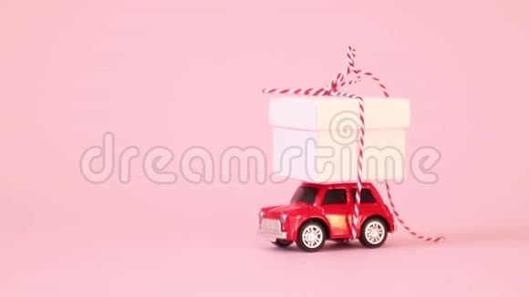 红色复古玩具车送礼盒带丝带蝴蝶结在粉红色背景上生日情人节妇女节视频视频的预览图