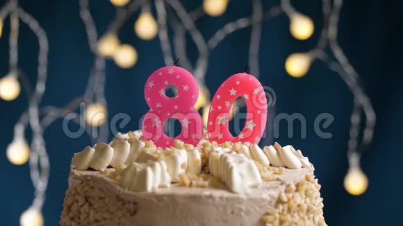 生日蛋糕80个数字燃烧由较轻的粉红色蜡烛在蓝色的背景蜡烛被点燃了慢动作视频的预览图