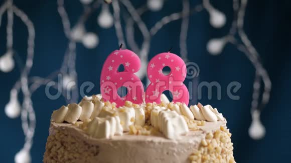 生日蛋糕有68个数字由较轻的粉红色蜡烛燃烧在蓝色的背景上蜡烛被点燃了慢动作视频的预览图
