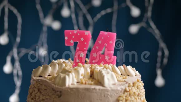 生日蛋糕74个数字燃烧由较轻的粉红色蜡烛在蓝色的背面蜡烛被点燃了慢动作视频的预览图
