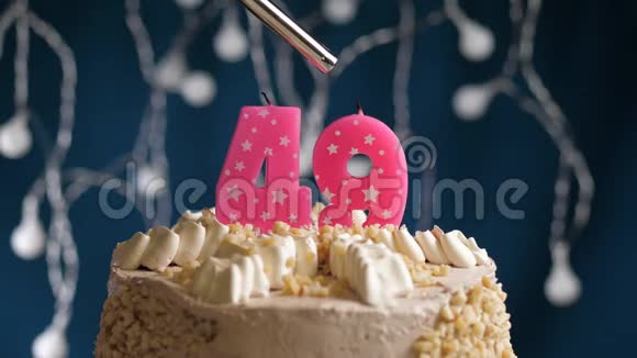 生日蛋糕49个数字燃烧由较轻的粉红色蜡烛在蓝色的背景蜡烛被点燃了慢动作视频的预览图