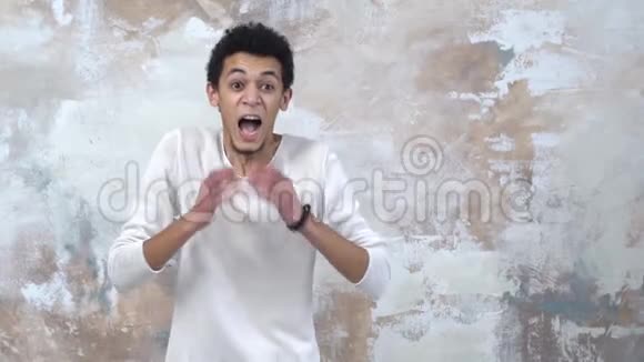 一个年轻人被隔离在漆墙上尖叫着抱着头害怕视频的预览图