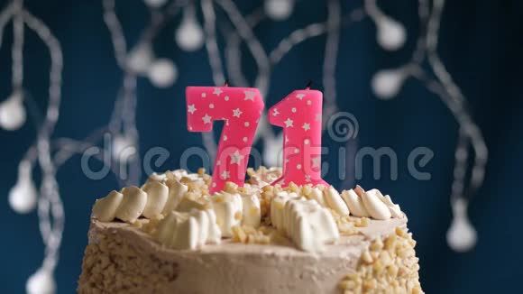 生日蛋糕71个数字燃烧由较轻的粉红色蜡烛在蓝色的背景蜡烛被点燃了慢动作视频的预览图