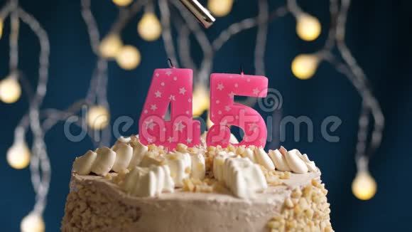 生日蛋糕45个数字燃烧由较轻的粉红色蜡烛在蓝色的背面蜡烛被点燃了慢动作视频的预览图