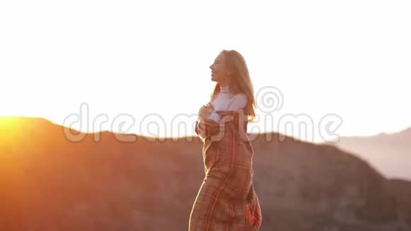 年轻迷人的女孩旅行者博客走在山上的格子阳光日落穿着暖和的衣服和格子呢视频的预览图