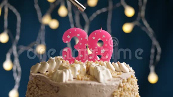 生日蛋糕39个数字燃烧由较轻的粉红色蜡烛在蓝色的背景蜡烛被点燃了慢动作视频的预览图