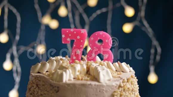 生日蛋糕有78个数字由较轻的粉红色蜡烛燃烧在蓝色的背景上蜡烛被点燃了慢动作视频的预览图