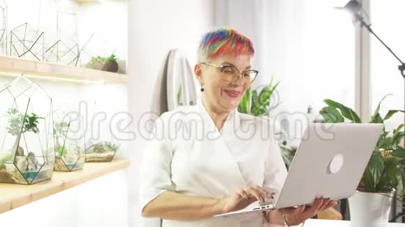 工作场所使用笔记本电脑的微笑花店画像视频的预览图